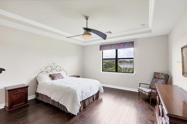 bedroom featuring baseboards, a ceiling fan, a raised ceiling, and dark wood-style flooring