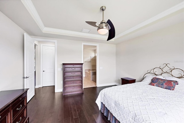 bedroom featuring baseboards, crown molding, dark wood-type flooring, and a tray ceiling
