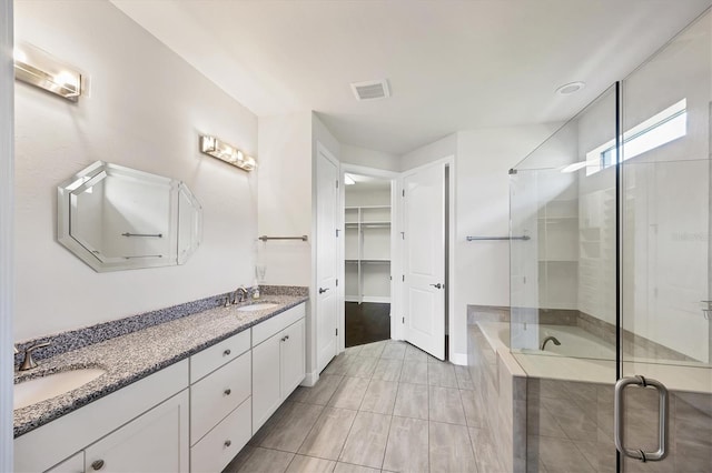 full bath featuring a sink, a walk in closet, a shower stall, and visible vents