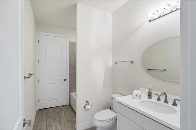 bathroom featuring vanity, baseboards, toilet, and a bath