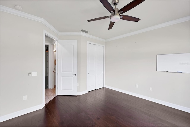 unfurnished bedroom featuring baseboards, dark wood-style flooring, crown molding, and visible vents