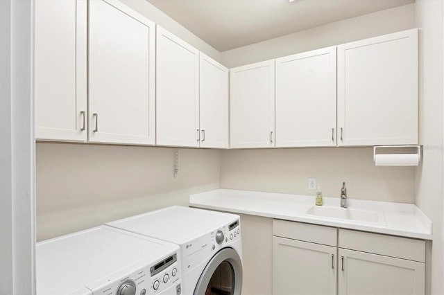 laundry room featuring washing machine and clothes dryer, a sink, and cabinet space
