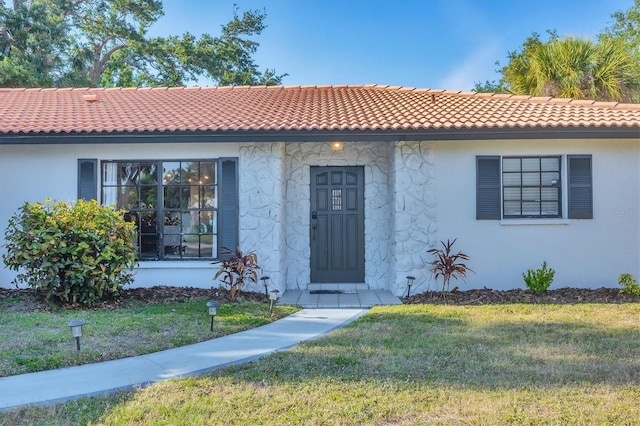 2301 Cass St, Sarasota, FL 34231 - view of front of home featuring a tile roof, a front yard, and stucco siding