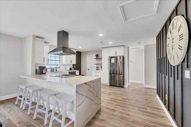 2301 Cass St, Sarasota, FL 34231 - kitchen featuring a sink, freestanding refrigerator, a peninsula, island range hood, and light wood-type flooring