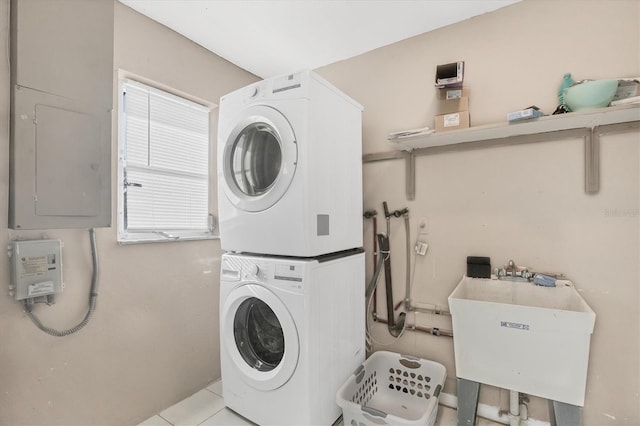 2301 Cass St, Sarasota, FL 34231 - washroom with stacked washer / drying machine, laundry area, a sink, light tile patterned floors, and electric panel