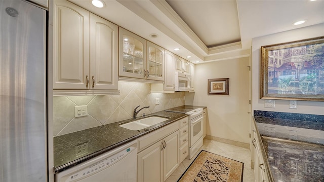 1212 Benjamin Franklin Dr Unit 503, Sarasota, FL 34236 - kitchen with a sink, white appliances, dark stone counters, decorative backsplash, and light tile patterned floors
