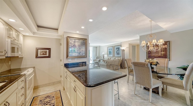 1212 Benjamin Franklin Dr Unit 503, Sarasota, FL 34236 - kitchen with a breakfast bar, an inviting chandelier, white appliances, open floor plan, and ornamental molding