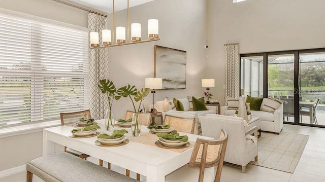 dining room featuring a high ceiling and a healthy amount of sunlight
