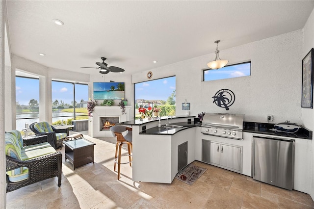 10819 Wicker Park Pl, Palmetto, FL 34221 - kitchen with fridge, dark countertops, a sink, a ceiling fan, and a peninsula