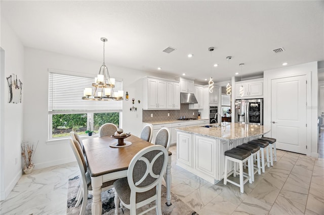 10819 Wicker Park Pl, Palmetto, FL 34221 - kitchen with stainless steel fridge, under cabinet range hood, a chandelier, and marble finish floor