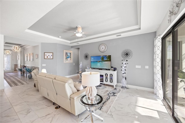 10819 Wicker Park Pl, Palmetto, FL 34221 - living area with baseboards, marble finish floor, ceiling fan with notable chandelier, and a tray ceiling