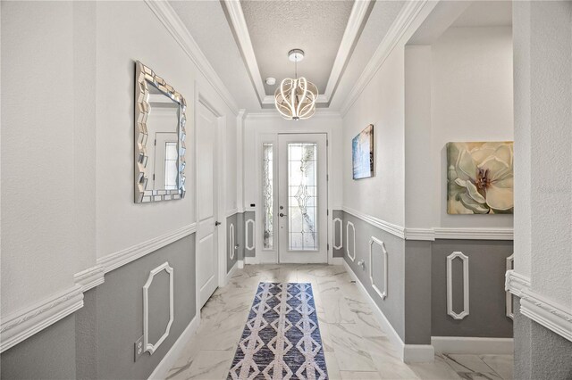 10819 Wicker Park Pl, Palmetto, FL 34221 - entrance foyer with a textured ceiling, a notable chandelier, ornamental molding, and marble finish floor