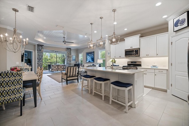 kitchen with visible vents, crown molding, appliances with stainless steel finishes, a sink, and light countertops