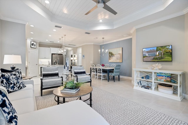 living room with crown molding, baseboards, ceiling fan with notable chandelier, a tray ceiling, and recessed lighting