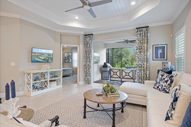 living room featuring ceiling fan, ornamental molding, a healthy amount of sunlight, and a raised ceiling