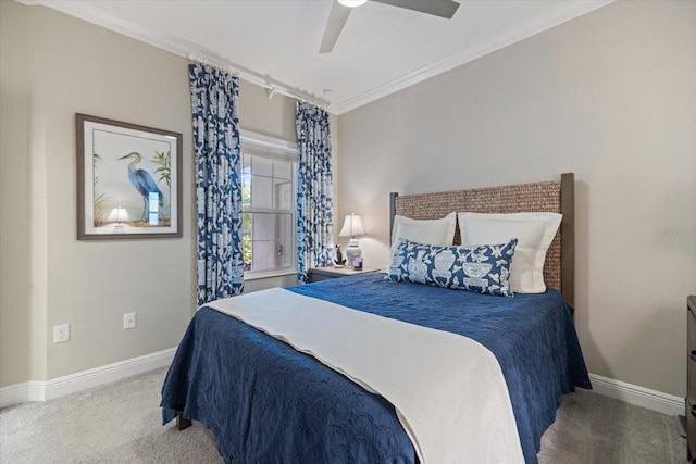 carpeted bedroom featuring baseboards, a ceiling fan, and crown molding