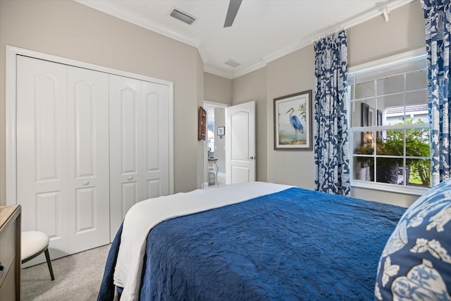 carpeted bedroom featuring a ceiling fan, visible vents, ornamental molding, and a closet