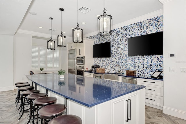 kitchen with decorative backsplash, baseboards, appliances with stainless steel finishes, and ornamental molding