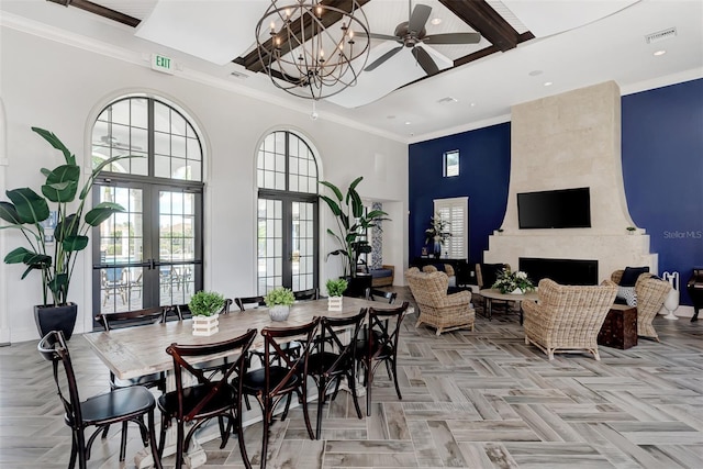 dining area with visible vents, a towering ceiling, recessed lighting, a tile fireplace, and french doors