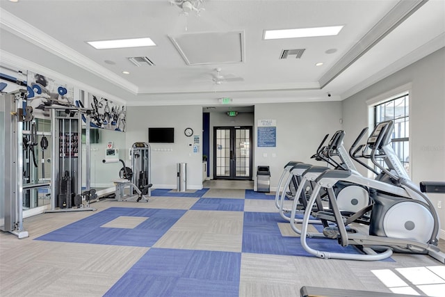 gym featuring a tray ceiling, visible vents, and carpet