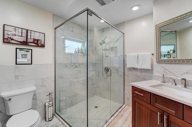 bathroom with tile walls, a stall shower, toilet, and marble finish floor