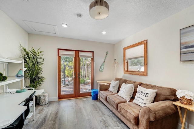 living area with recessed lighting, attic access, a textured ceiling, and wood finished floors