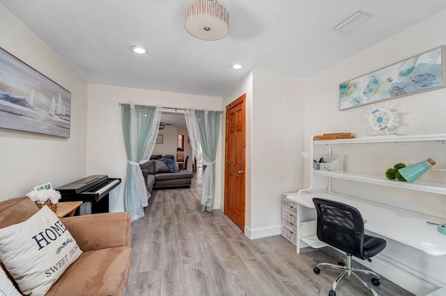 office space with recessed lighting, baseboards, light wood finished floors, and visible vents