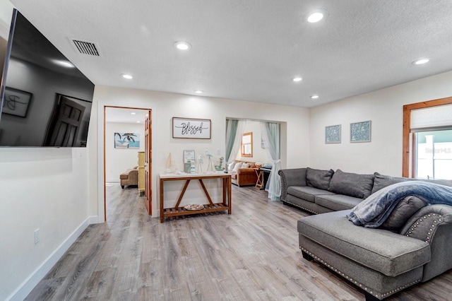 living room featuring recessed lighting, visible vents, and light wood finished floors