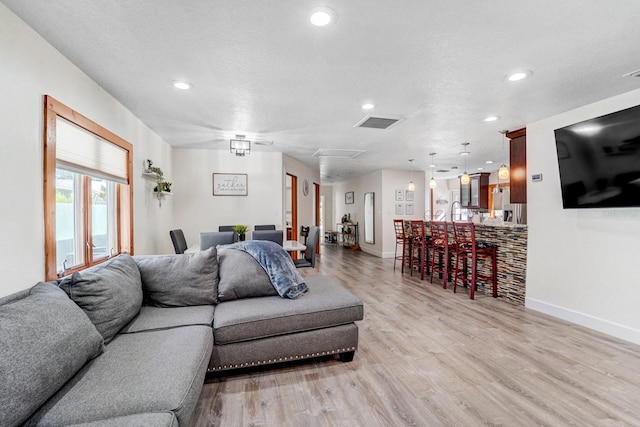 living area featuring recessed lighting, baseboards, visible vents, and light wood finished floors