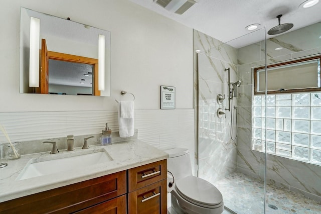 full bath with toilet, visible vents, a marble finish shower, and vanity