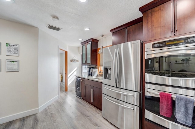 kitchen featuring visible vents, appliances with stainless steel finishes, baseboards, beverage cooler, and light wood-style flooring