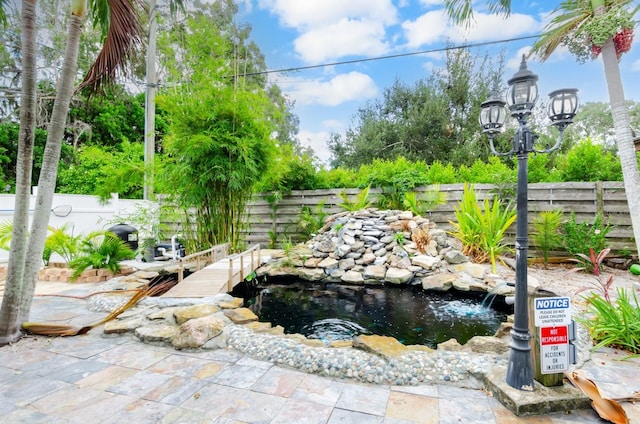 view of yard featuring a small pond and a fenced backyard