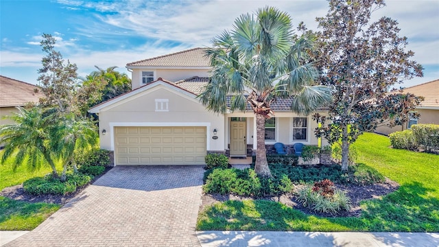 view of front of home featuring an attached garage, decorative driveway, stucco siding, and a tile roof
