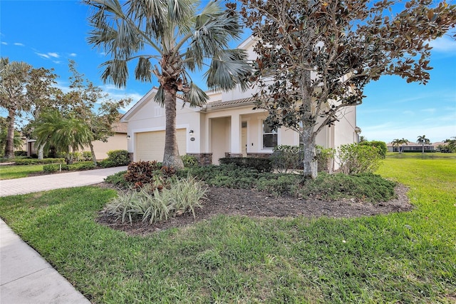 view of front of house featuring a garage, driveway, a front yard, and stucco siding