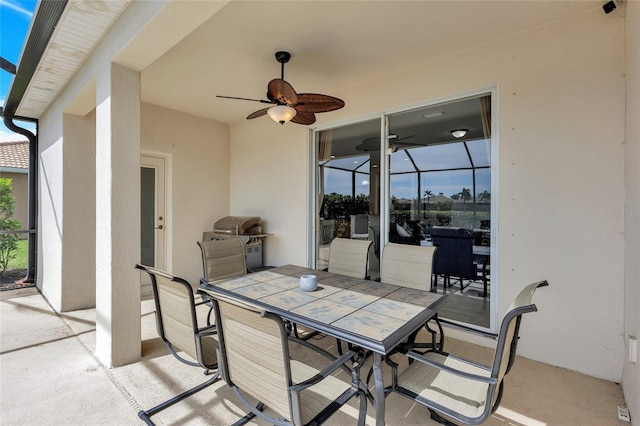view of patio featuring a ceiling fan, outdoor dining area, and a grill