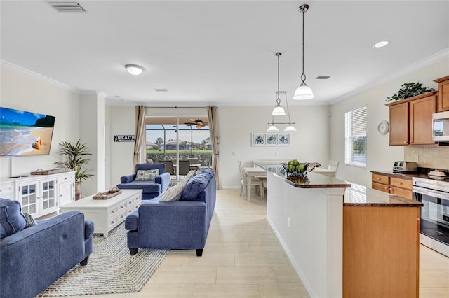 kitchen with crown molding, stainless steel appliances, open floor plan, and visible vents