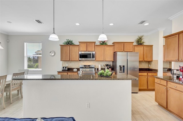 kitchen with dark stone countertops, an island with sink, tasteful backsplash, and stainless steel appliances
