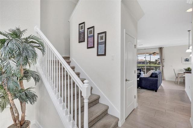 stairway featuring baseboards and wood finished floors