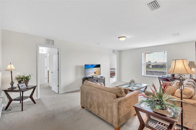 living area featuring baseboards, visible vents, and light carpet