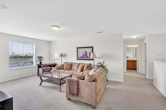 living area with baseboards, light carpet, and visible vents