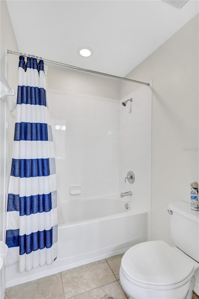 bathroom featuring toilet, tile patterned floors, and shower / tub combo