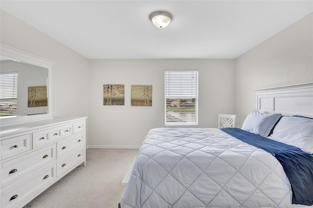 bedroom with baseboards and light carpet