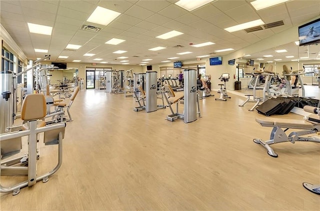 exercise room with visible vents, a paneled ceiling, and wood finished floors