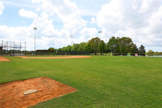 surrounding community with a yard, a water view, and fence