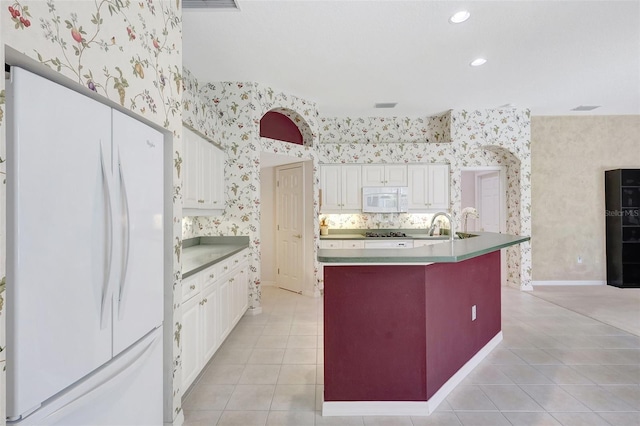 4730 Old Farm Rd, Sarasota, FL 34233 - kitchen with light tile patterned floors, wallpapered walls, white appliances, and white cabinetry