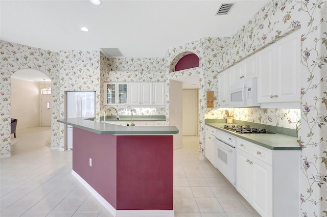 4730 Old Farm Rd, Sarasota, FL 34233 - kitchen featuring white appliances, arched walkways, wallpapered walls, light tile patterned floors, and visible vents
