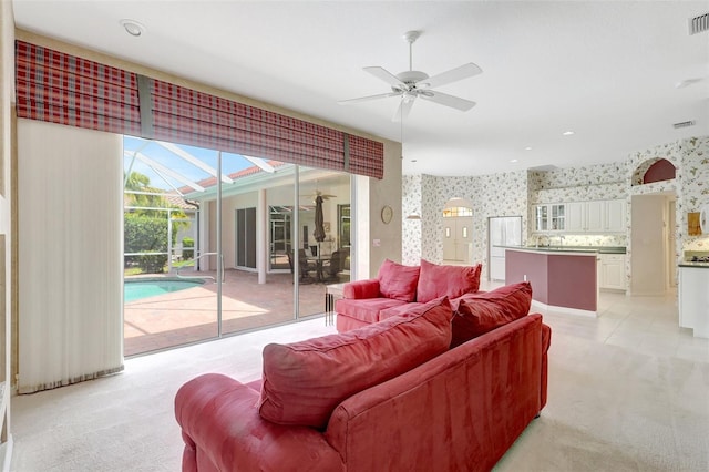 4730 Old Farm Rd, Sarasota, FL 34233 - living area with a sunroom, a ceiling fan, wallpapered walls, and light carpet