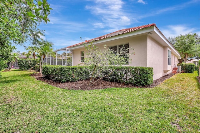 4730 Old Farm Rd, Sarasota, FL 34233 - view of property exterior featuring a lawn, glass enclosure, stucco siding, and a tiled roof
