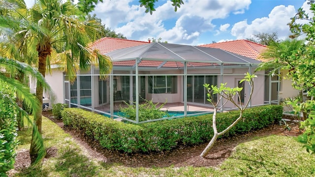 4730 Old Farm Rd, Sarasota, FL 34233 - back of house featuring a tiled roof, a swimming pool, glass enclosure, and stucco siding