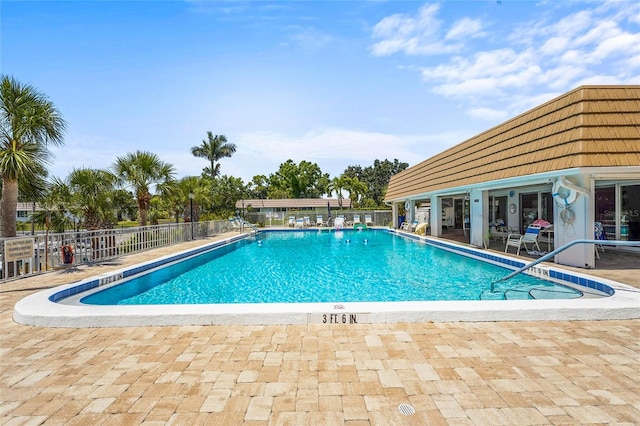 pool with a patio and fence